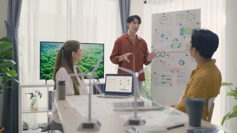 A dynamic team engages in a strategic meeting about solar energy and ESG initiatives in a modern, eco-conscious office setting.