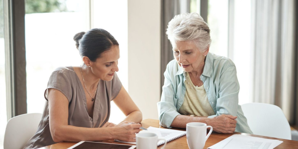Daughter helping her elderly mother with documents