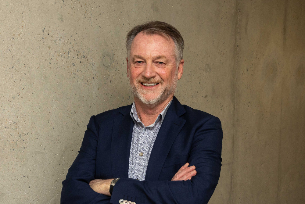 Business man with beard, arms crossed and smiling, and looking at camera