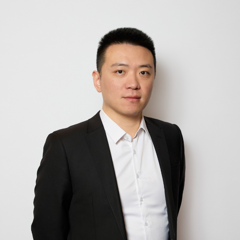 Business man with dark hair, looking at camera wearing white shirt and black jacket