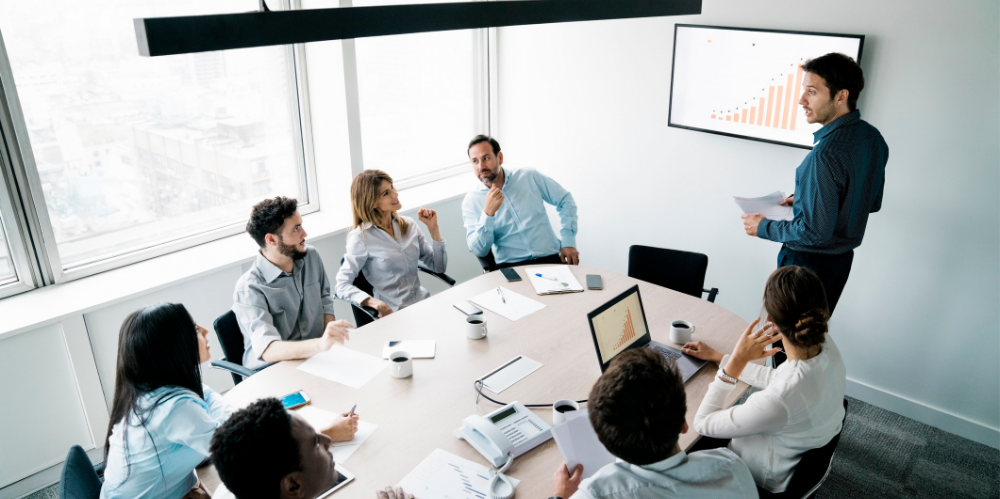 A group shot of corporate professionals discussing graphics and numbers.