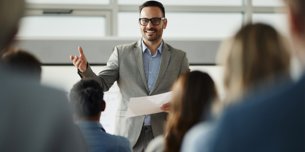 Business leader talking to his colleagues during an education event in board room.