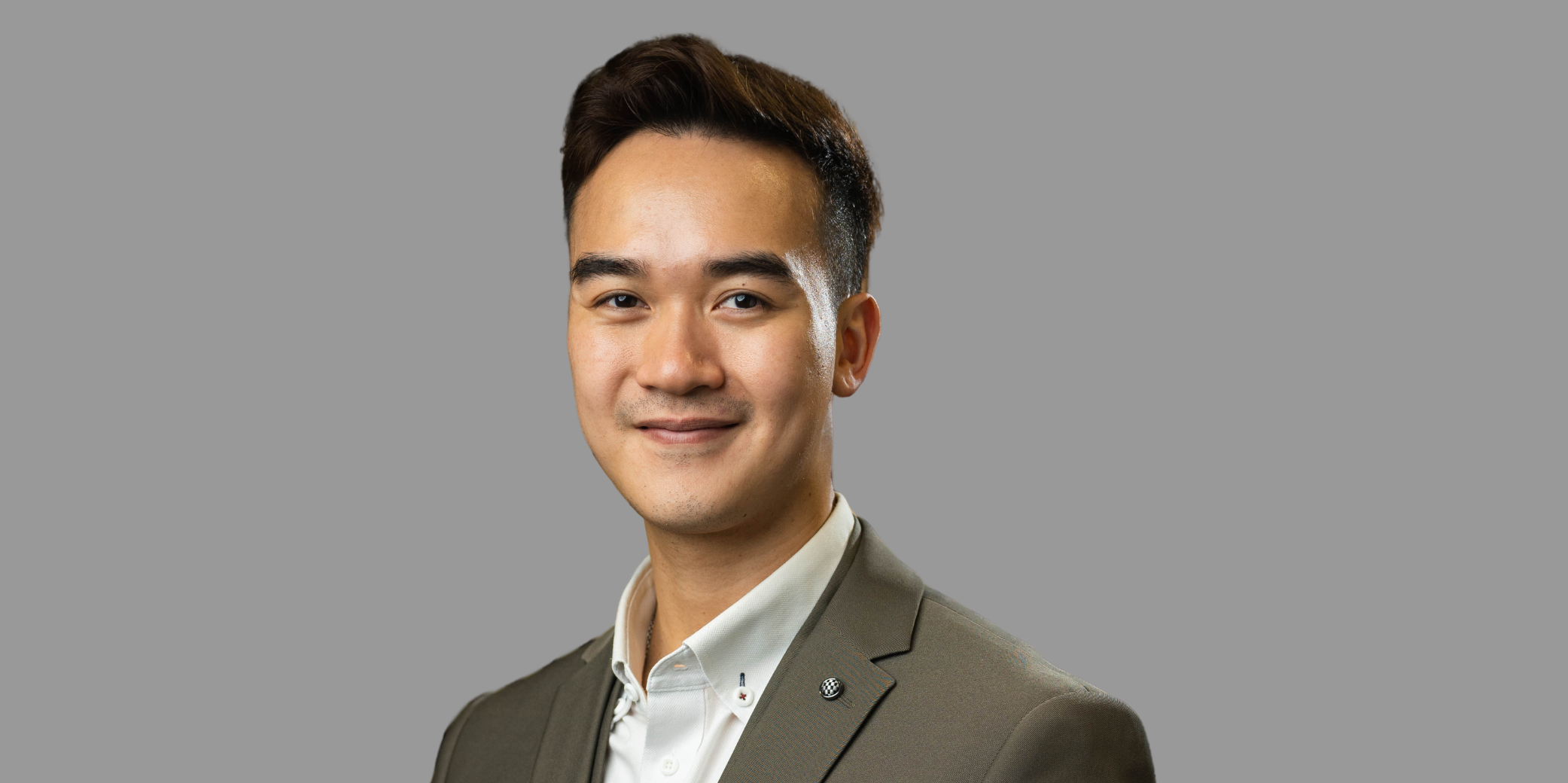 Business man in green grey suit and white shirt looking at camera 