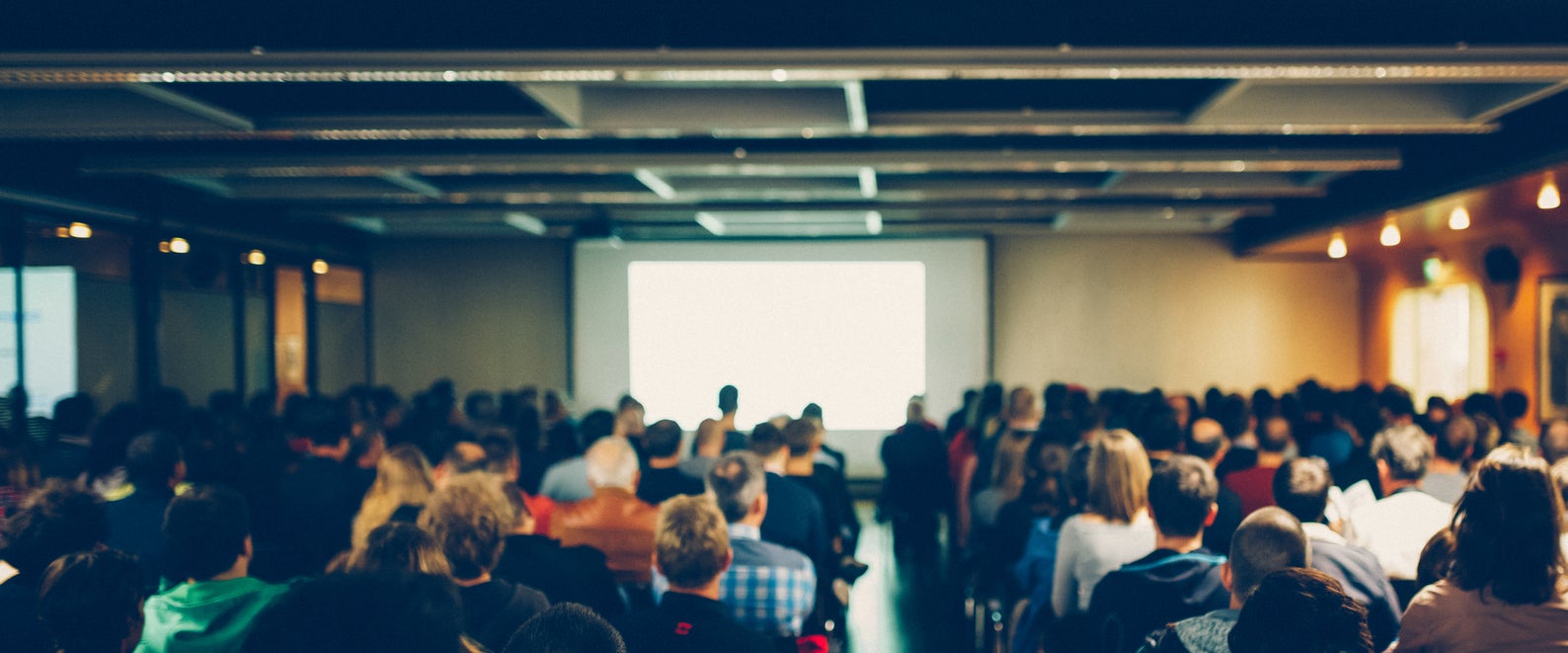 Business conference with unrecognizable audience. Shallow DOF, selective focus.