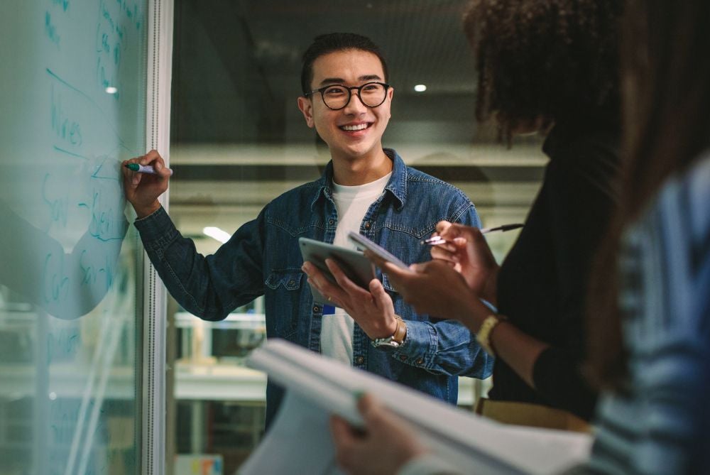 Man writing on whiteboard.