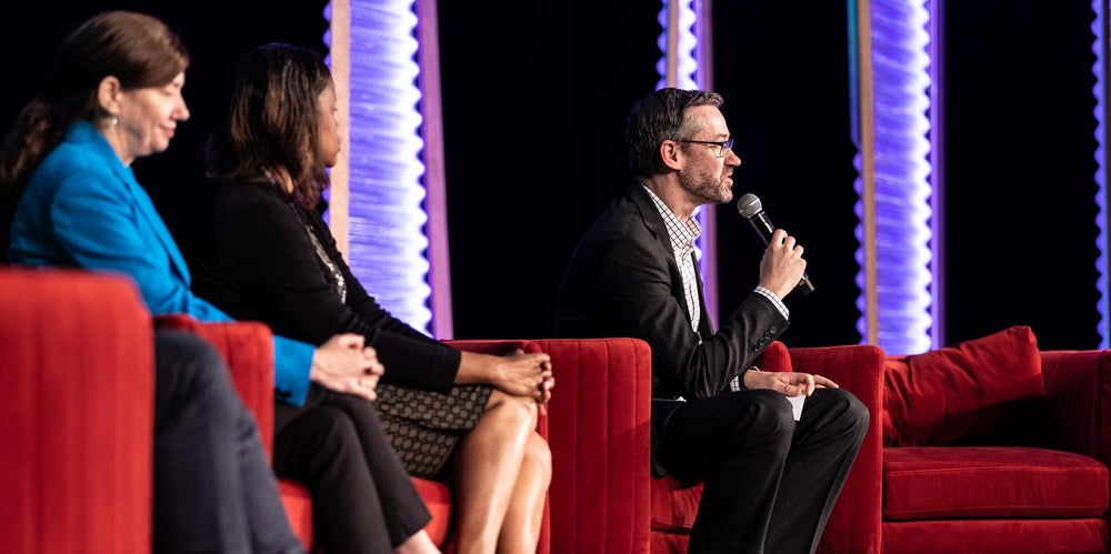 Three speakers onstage at the 2023 International Congress of Actuaries hosted in Sydney by the Actuaries Institute.