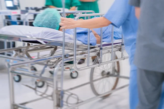 Motion blur of staff rushing patient to emergency room at hospital.