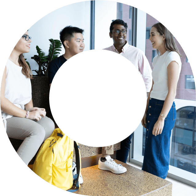 Four young actuaries standing talking to each other and networking