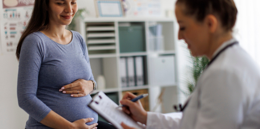 Shot of a female doctor going over paperwork with a pregnant patient
