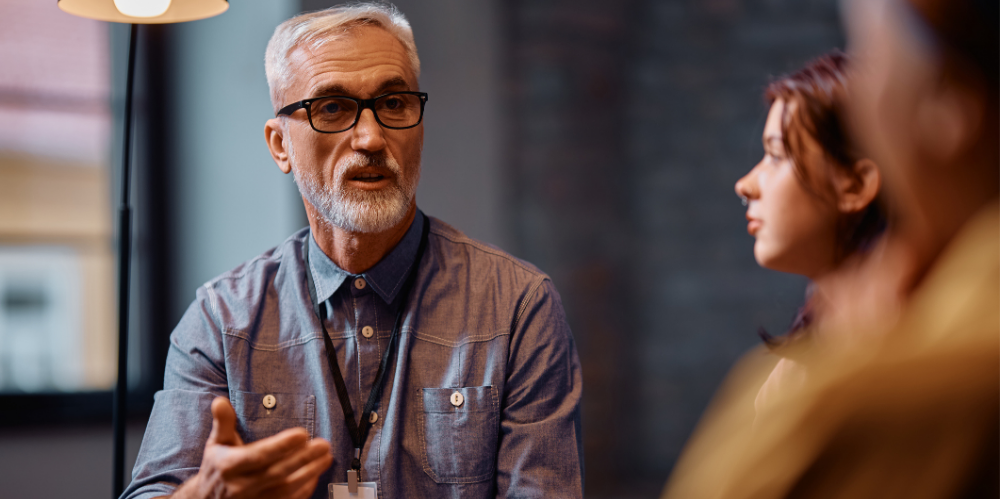 Mature counselor leading a mental health therapy session at community centre