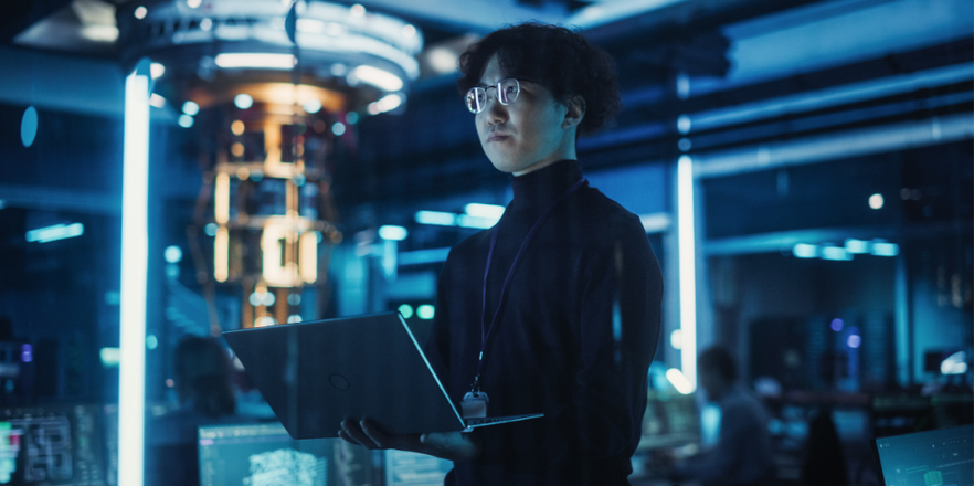 Software developer using a laptop to monitor the work of a quantum computer, focusing on data flow, compute and hardware stability.