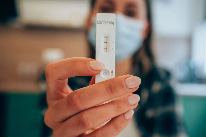 Photo of person holding a positive Covid test