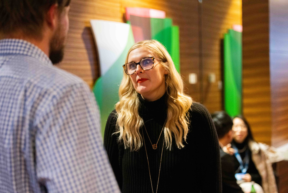 Women with long blonde hair and black polo jumper