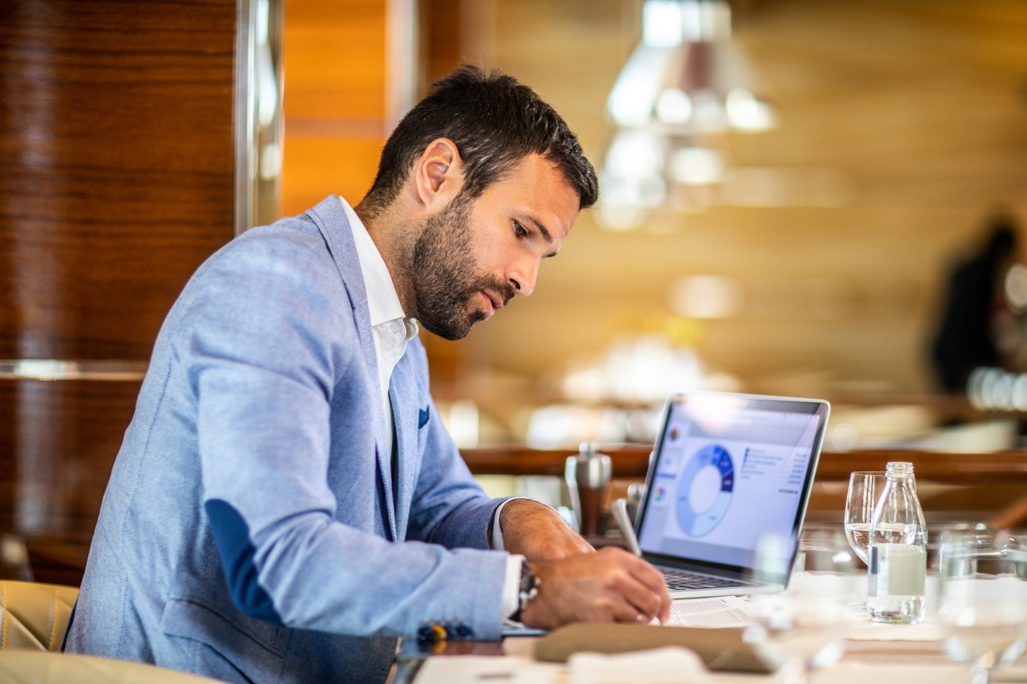 Businessman working at his desk, writing notes from a diagram