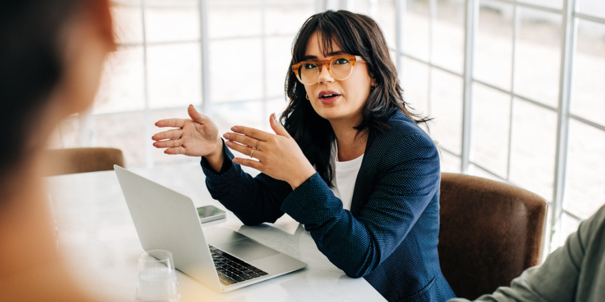 Woman with glasses in team strategic planning meeting.