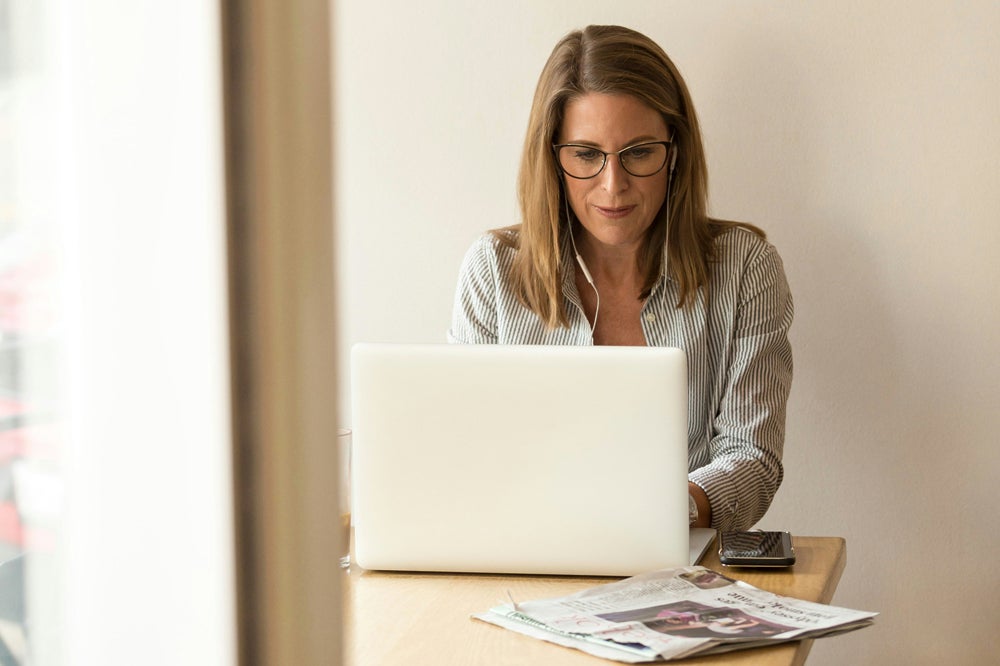 Woman with blonde hair typing on laptop