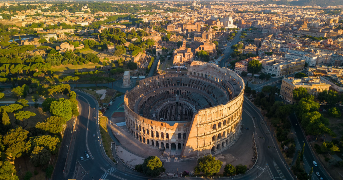 An aerial view of the historic Colosseum and surrounding buildings in Rome, Italy.
