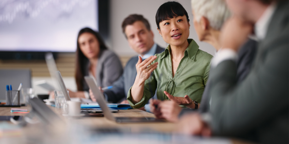 A women communicating with her colleague during a meeting in the office.