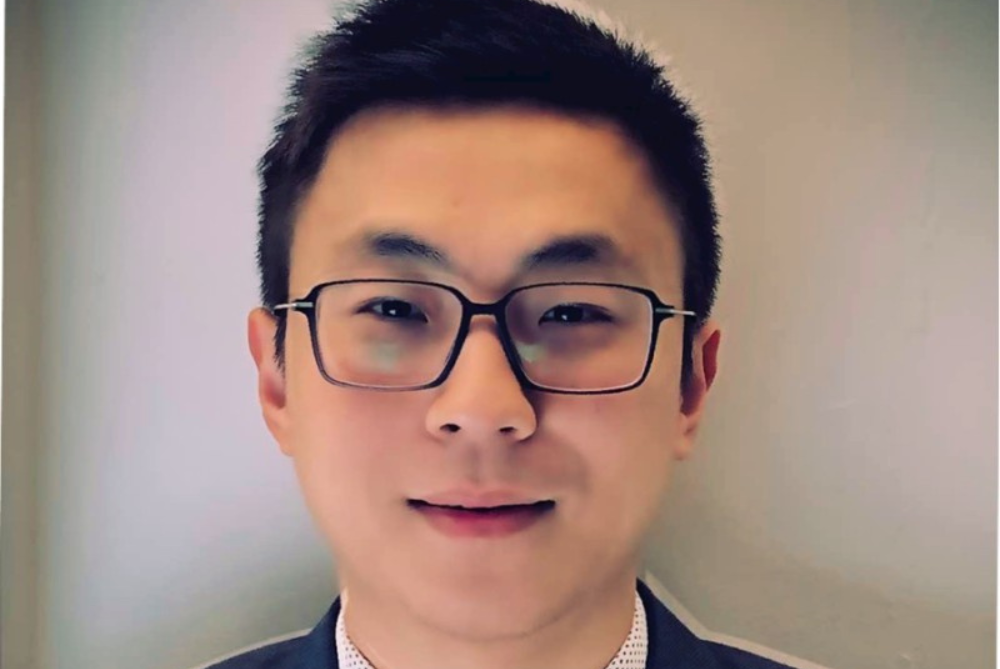 Portrait photo of male, smiling and looking at camera, with short black hair