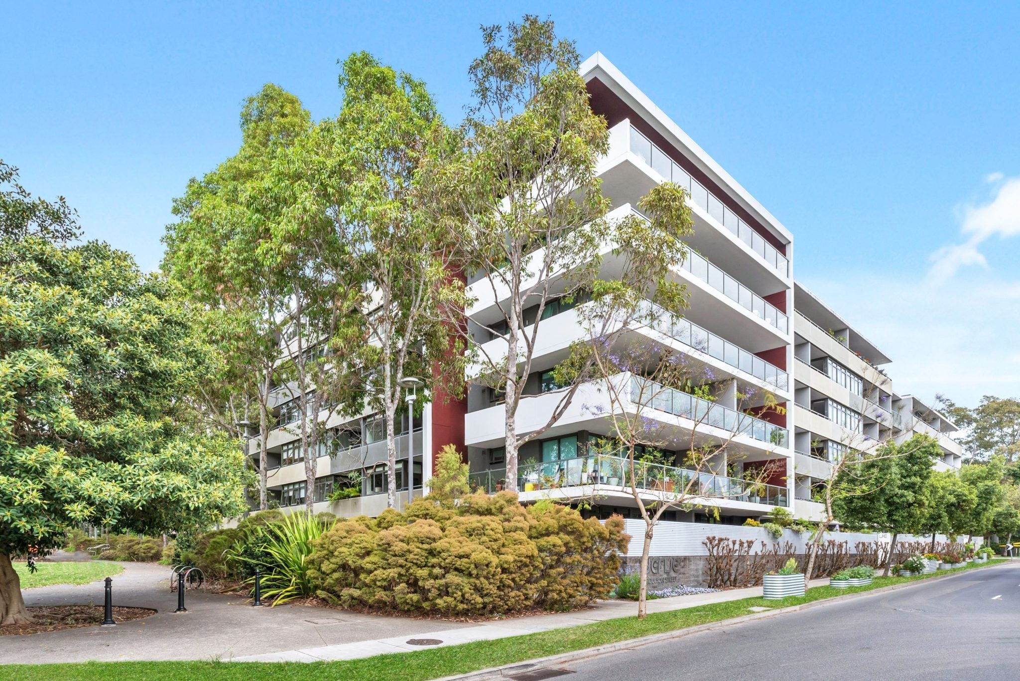 An apartment block that is surrounded by greenery.