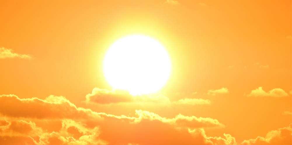 An extremely hot sun coming through the clouds