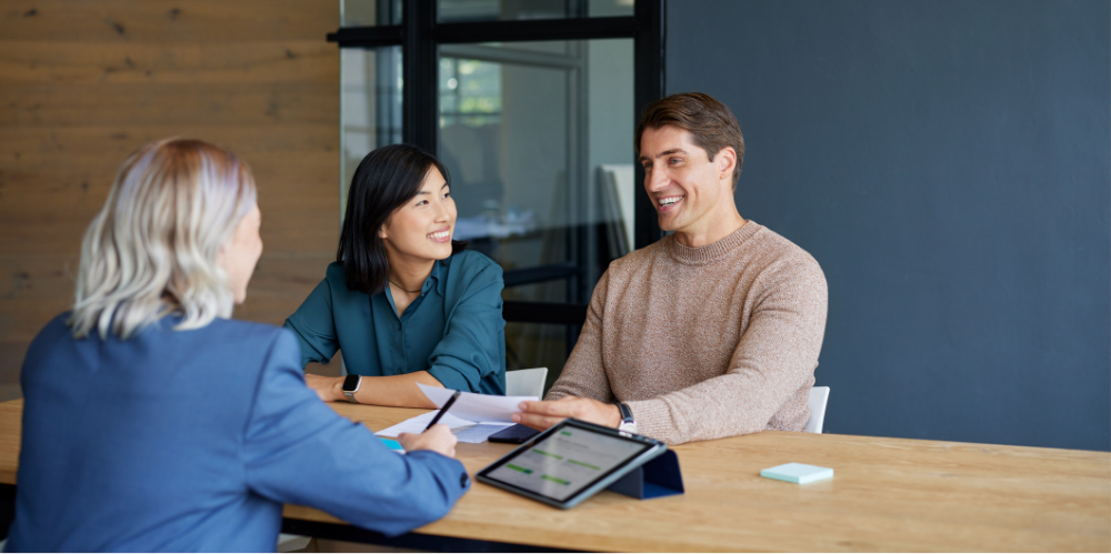 Smiling multiethnic couple receiving financial guidance from advisor 