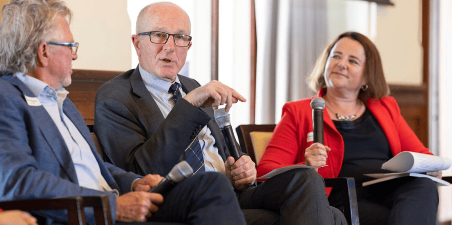 Three speakers holding microphones 
