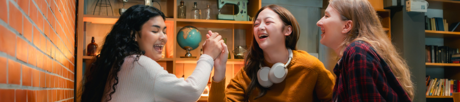 Three women laughing playing trivia
