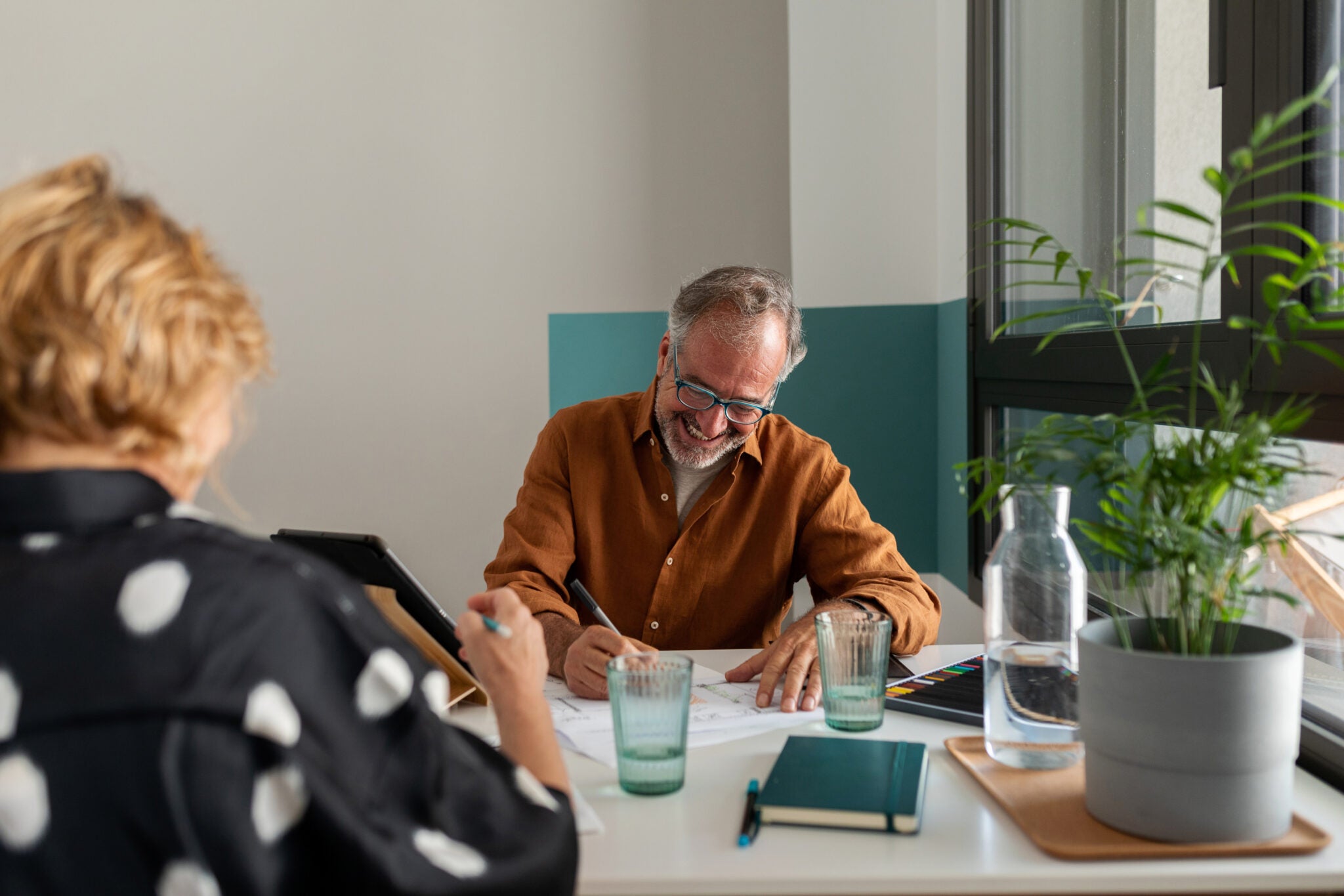 Front view of mature couple working together and having fun at modern office