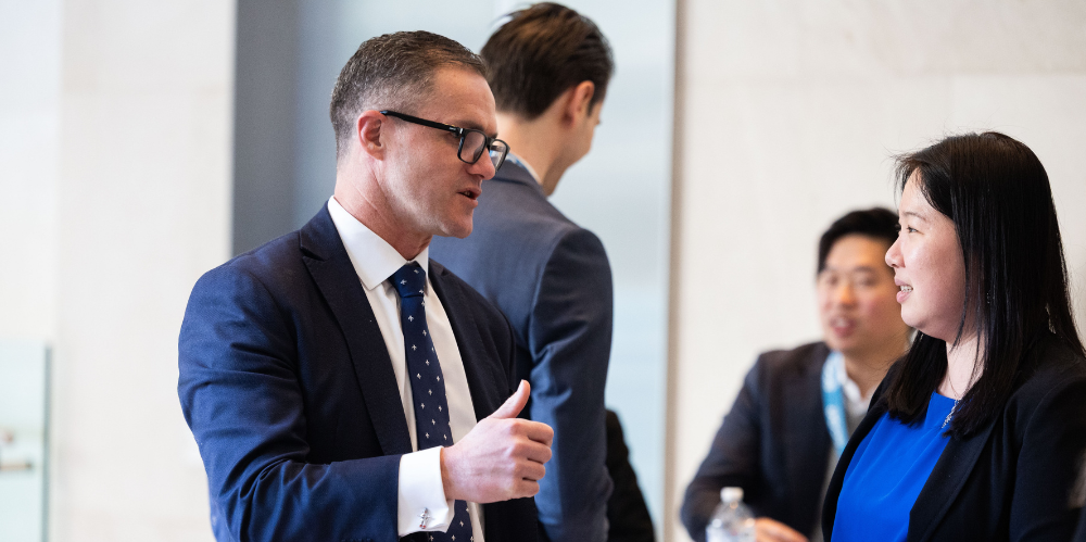 Business man in hallyway speaking and guestering to a women 