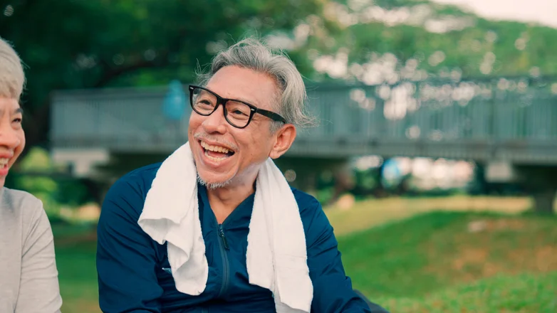 Elderly Asian people sit and relax after exercising outdoors.