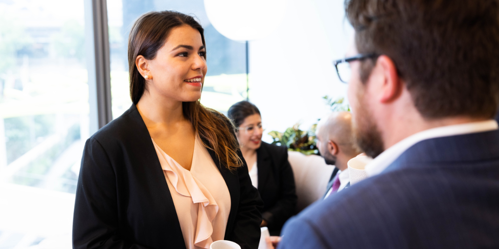 Professional woman standing with colleagues - Young Actuaries Conference 2026