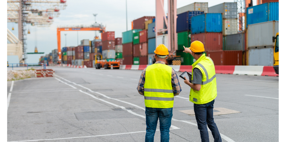 Dock workers overseeing shipping containers at a busy port
