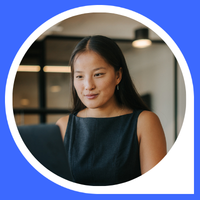 Woman working on her laptop across the Actuaries Institute logo and blue background