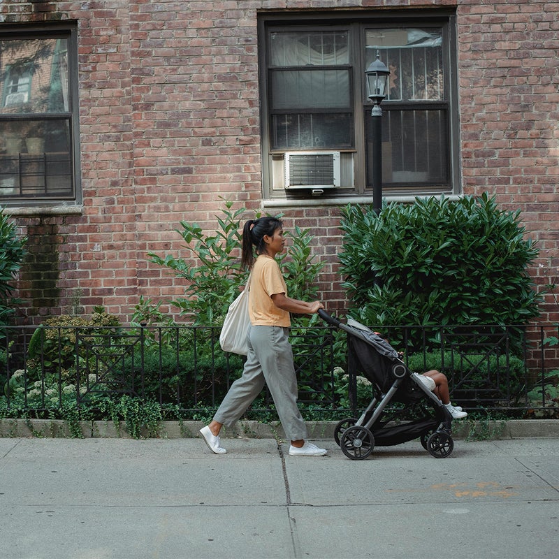 Woman pushing stroller down the street