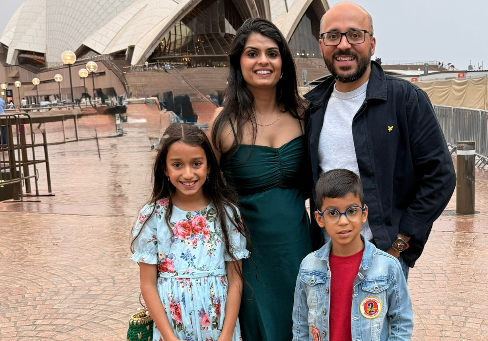 A family standing in front of the Sydney Opera House.