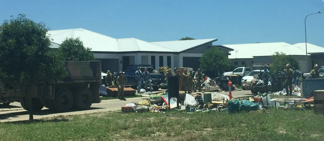 Australian Defence Force members assist with the clean-up of a newly developed Townsville Estate
