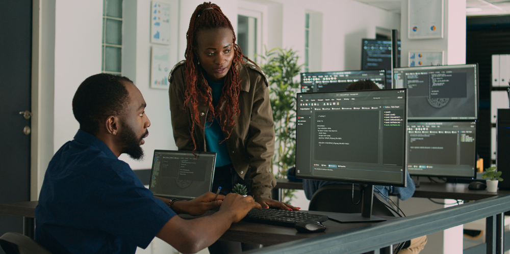 Worker showing a colleague some code