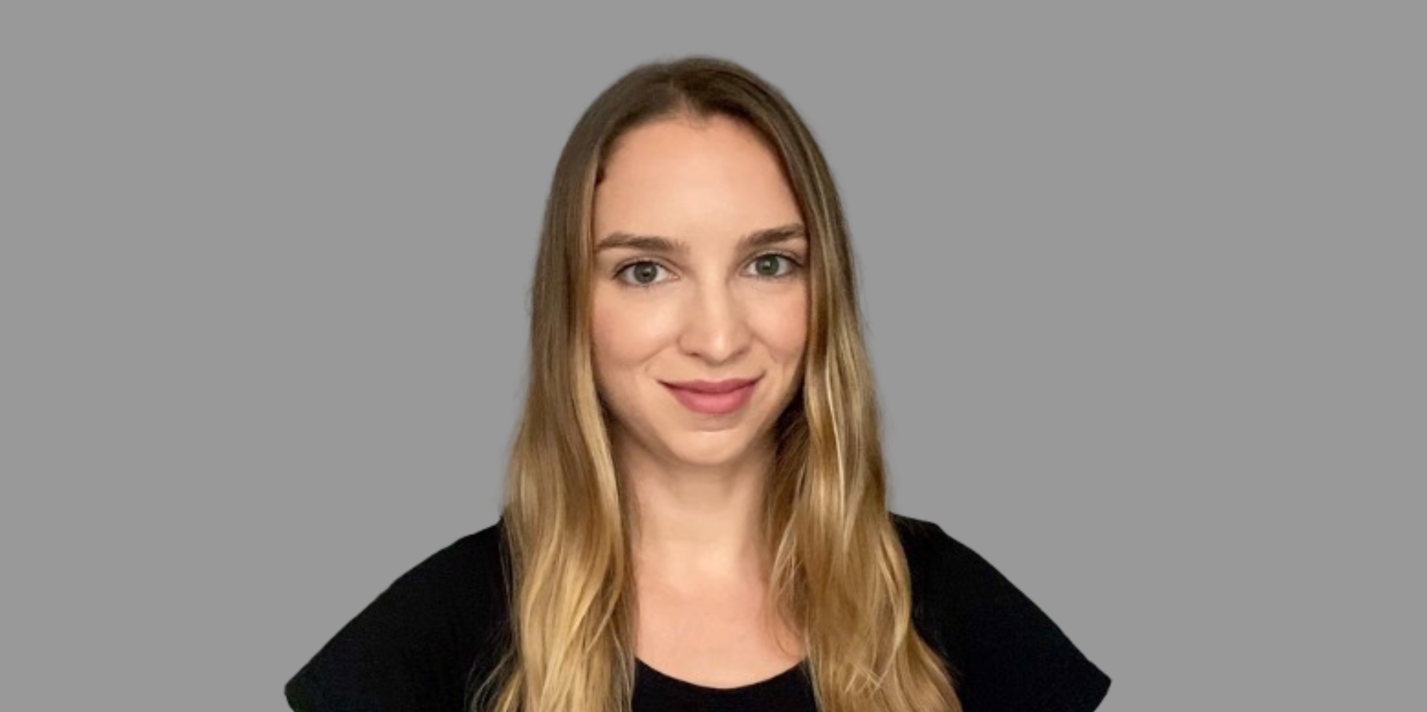 Female with long blonde hair smiling at camera with black shirt and grey background