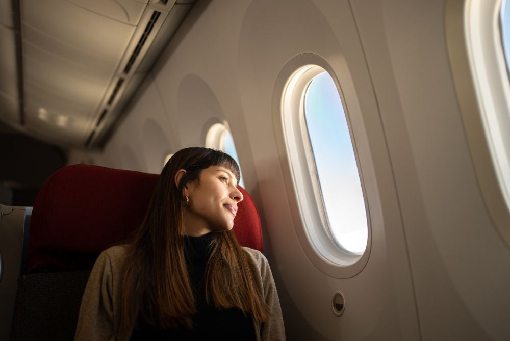 Woman looking out aeroplane window.
