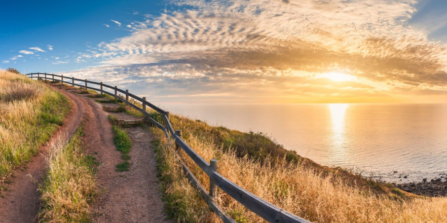 Beautiful sunset over the ocean, with a trail winding to the left