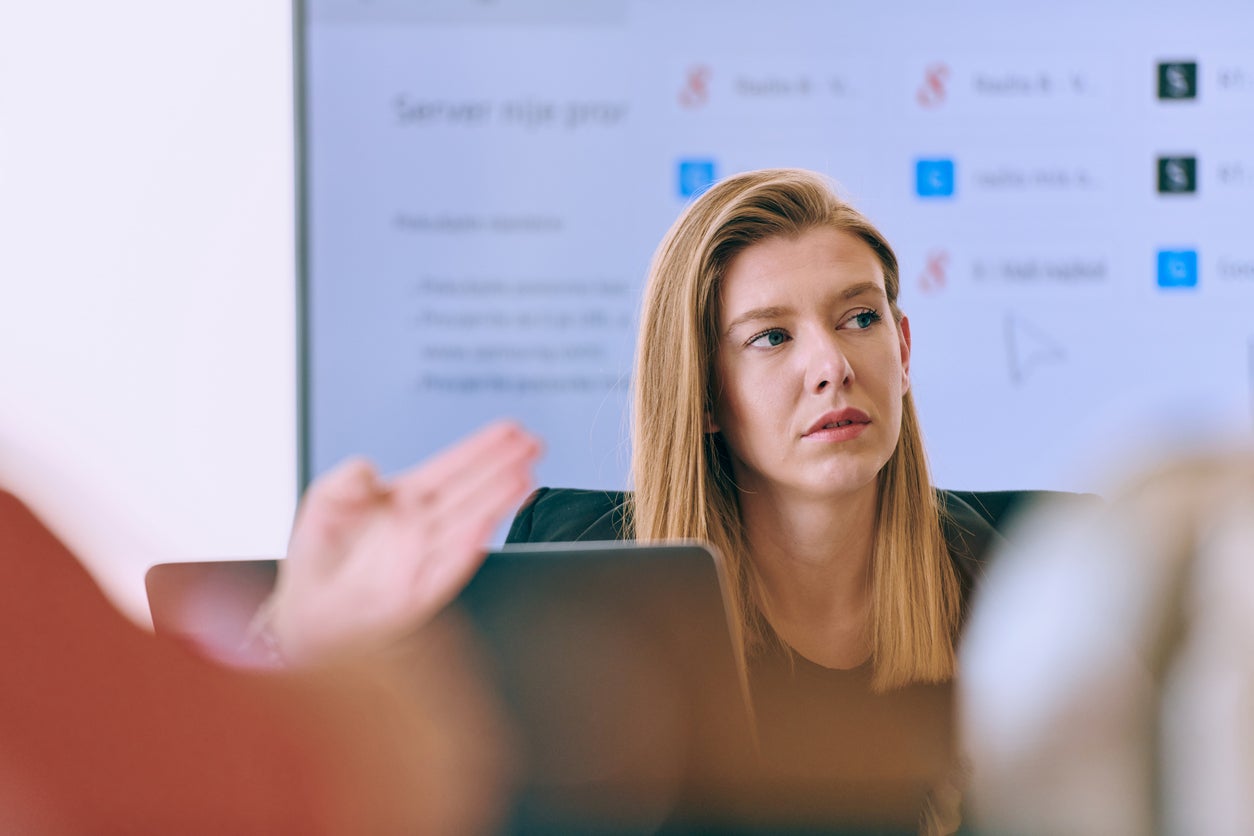Capturing the essence of leadership and collaboration, this headshot portrait showcases a professional businesswoman attentively guiding a productive meeting with colleagues, exuding confidence and expertise.