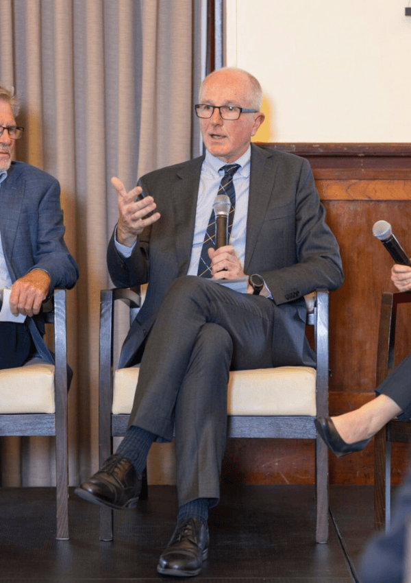 Government Actuary on conference stage presenting with microphone in their hand