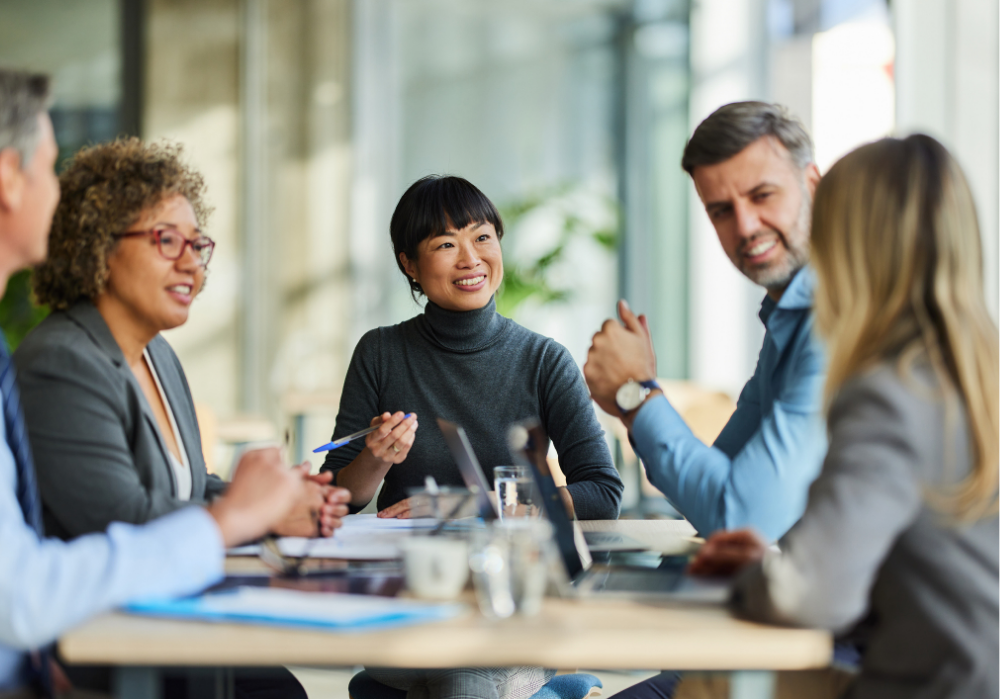 A collective group of corporate workers - various genders and cultures represented - having a meeting.