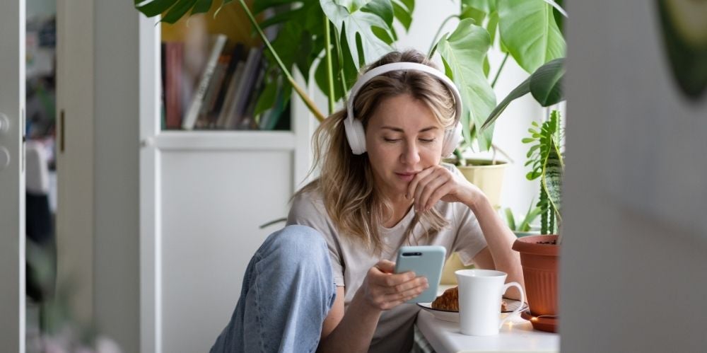 Women listening to podcast at home