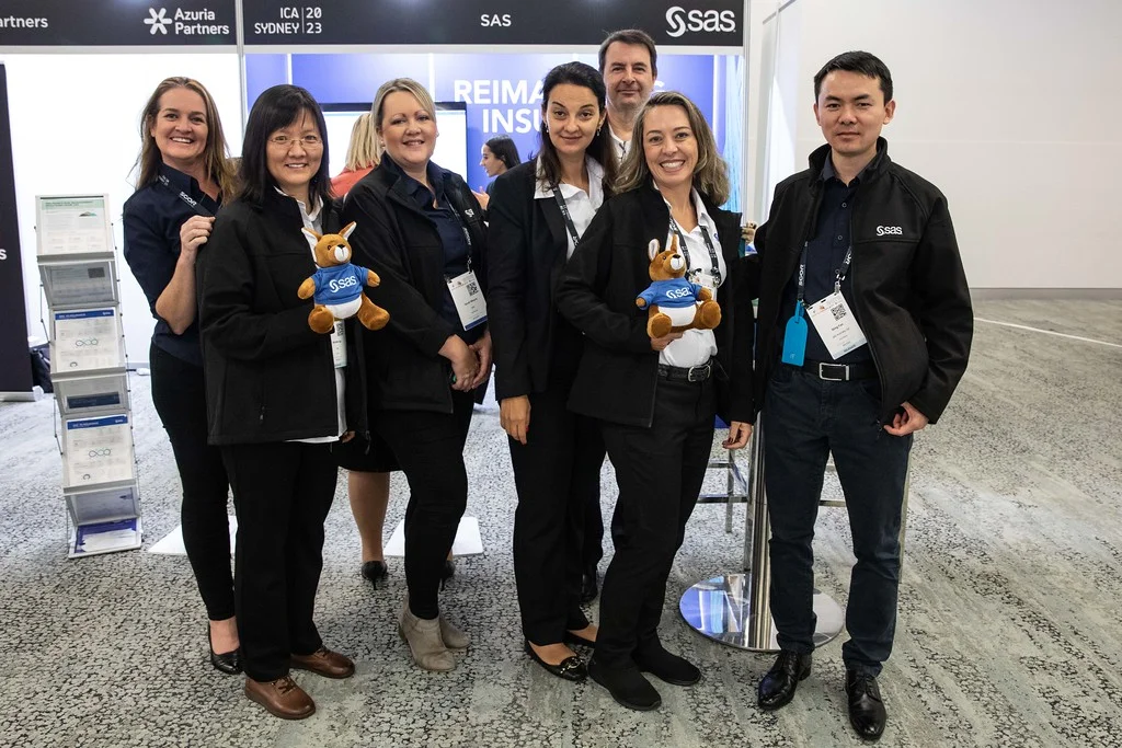 James (far back) and the SAS Team at their ICA2023 booth.