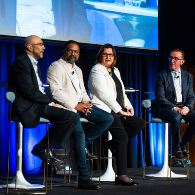 Ian Hamm speaking while Suhit Anantula, Jacki Johnson and Andrew Matthews listen during the plenary panel discussion