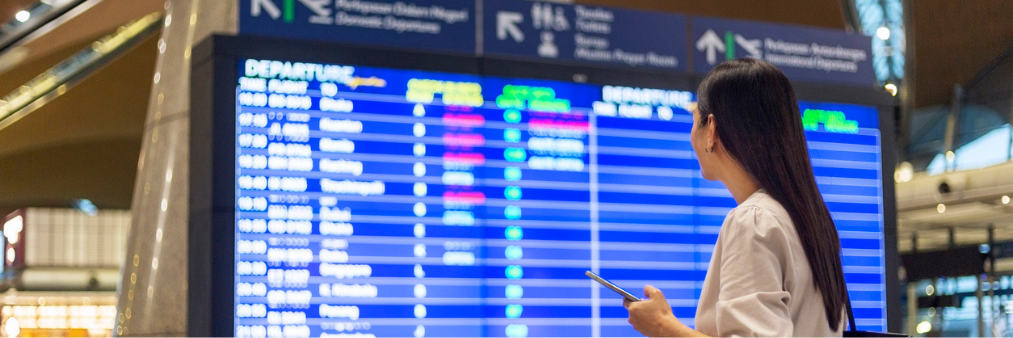 image of women in an airport looking and flight departure times 