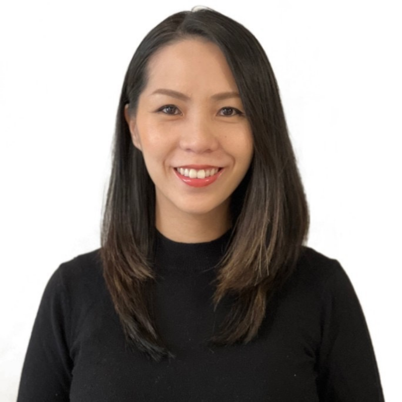 Women smiling at camera with black hair to shoulders and black top