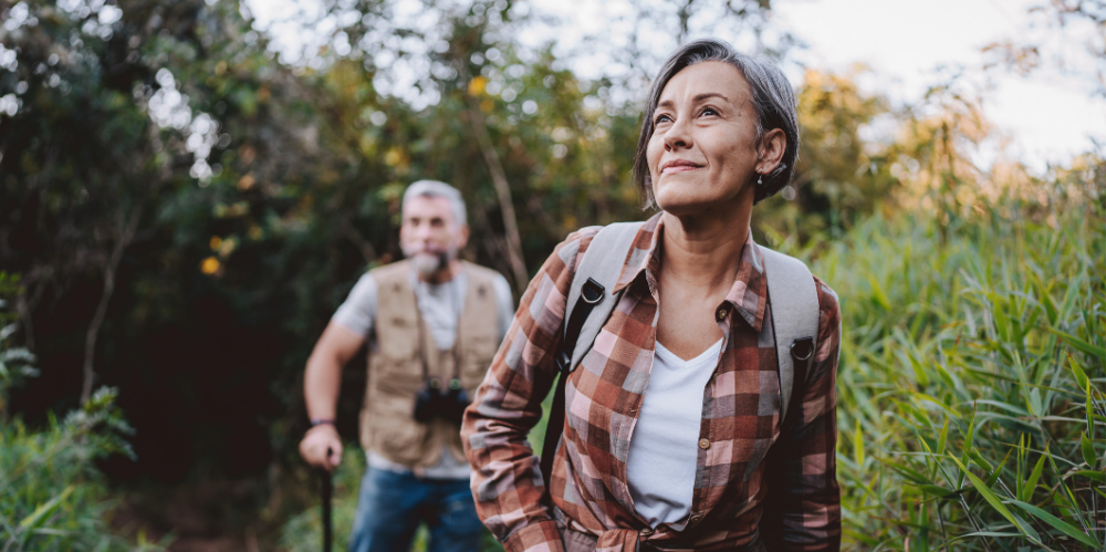 Senior couple walking on forest mountain trail